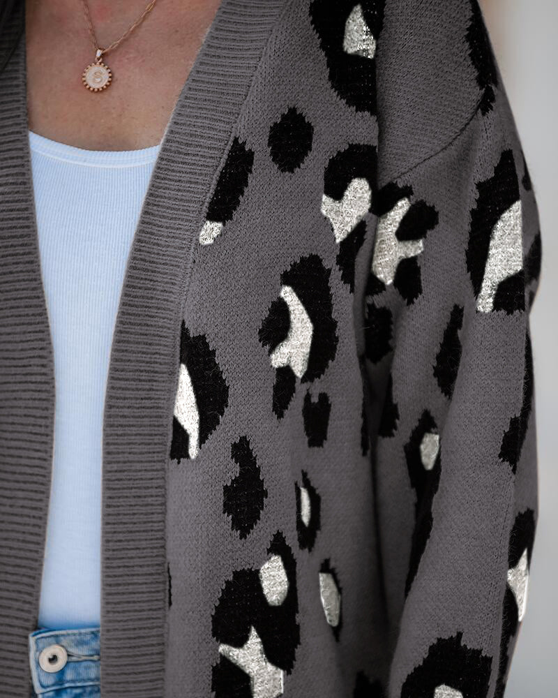 Leopard print longline open-front cardigan layered over a white top and light blue jeans.