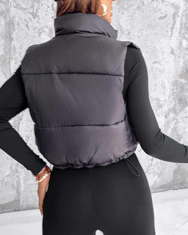 Stand Collar Zip-Up Cropped Puffer Vest with Drawstring Hem over black top and pants.