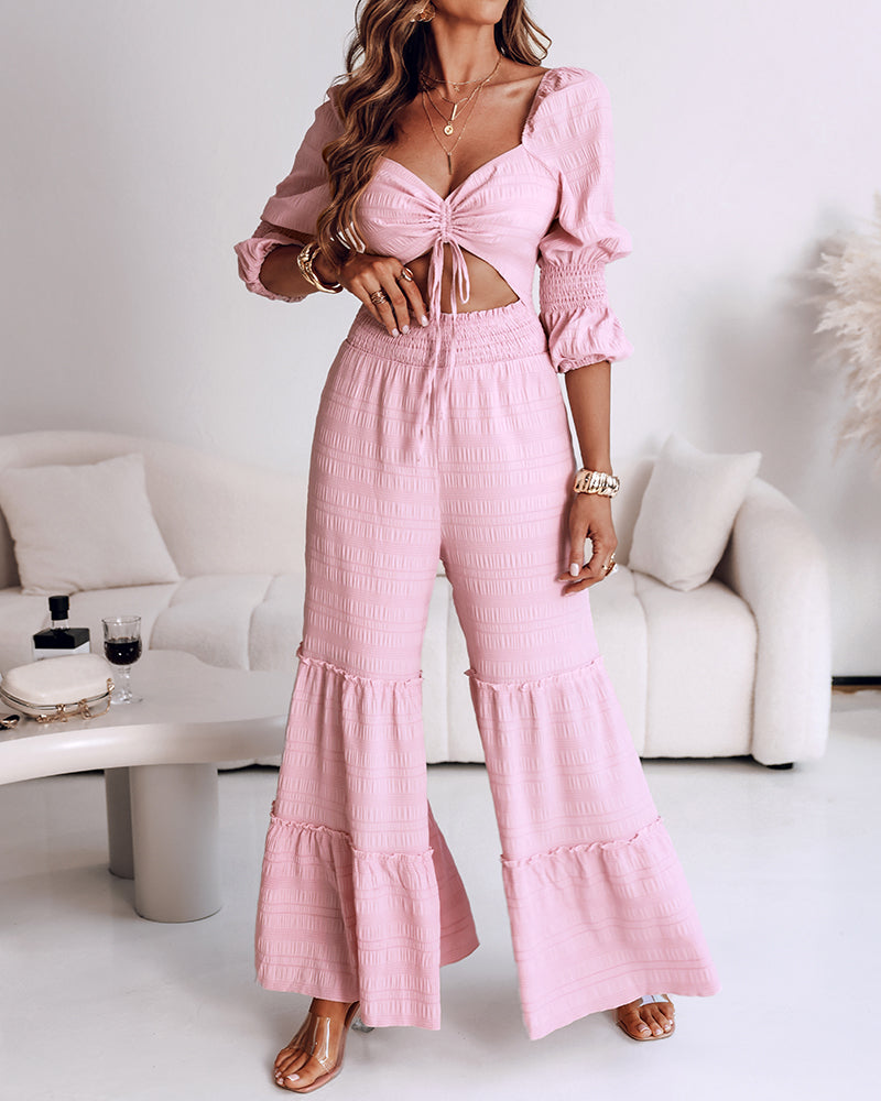 A KOAD'CLO wide leg jumpsuit with sweetheart neck, puff sleeves, and ruffle hem.