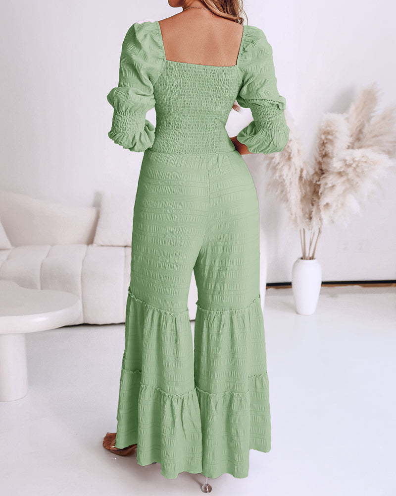 Light green jumpsuit with sweetheart neckline, puff sleeves, shirred bodice, and ruffled hem.