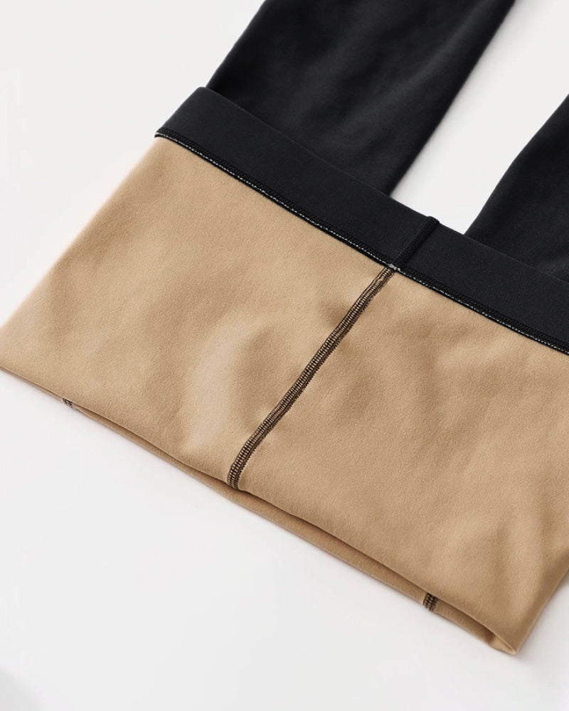 Pants with a black outer layer and beige lining, featuring a bold color-block effect.
