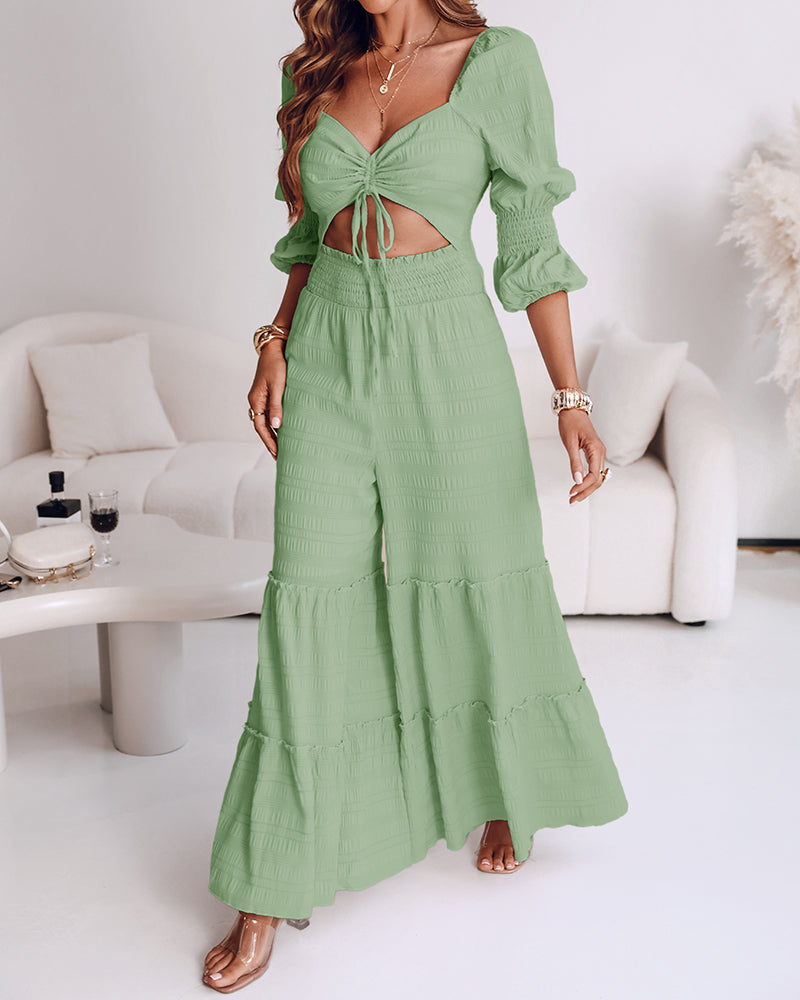 Light green KOAD'CLO jumpsuit with sweetheart neckline, puff sleeves, and ruffled wide legs.