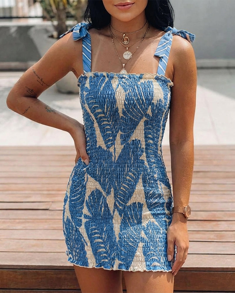 Blue and beige tropical print mini dress with bow tie shoulders and frilled detailing.
