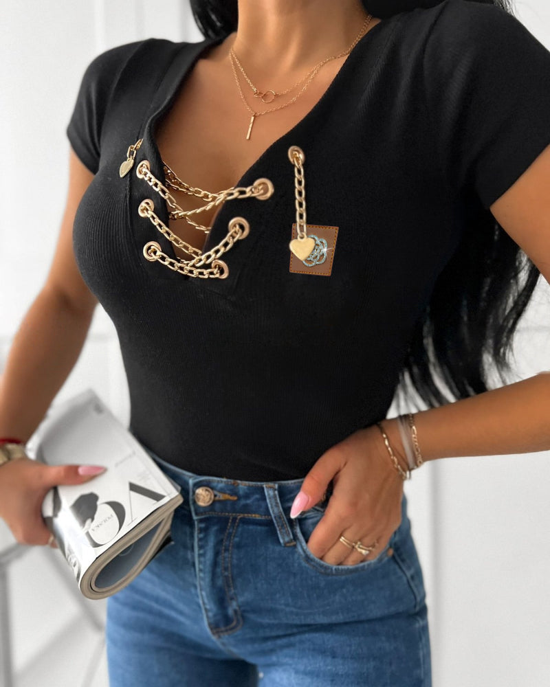 KOAD'CLO V-Neck T-Shirt with lace-up detail and rhinestone accents, blue jeans.