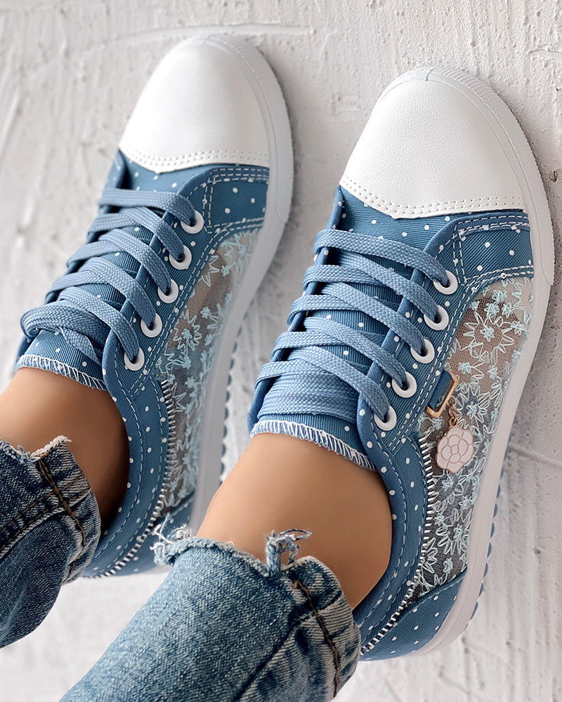 Floral embroidered polka dot sneakers with white toes, paired with light-wash frayed-hem jeans.