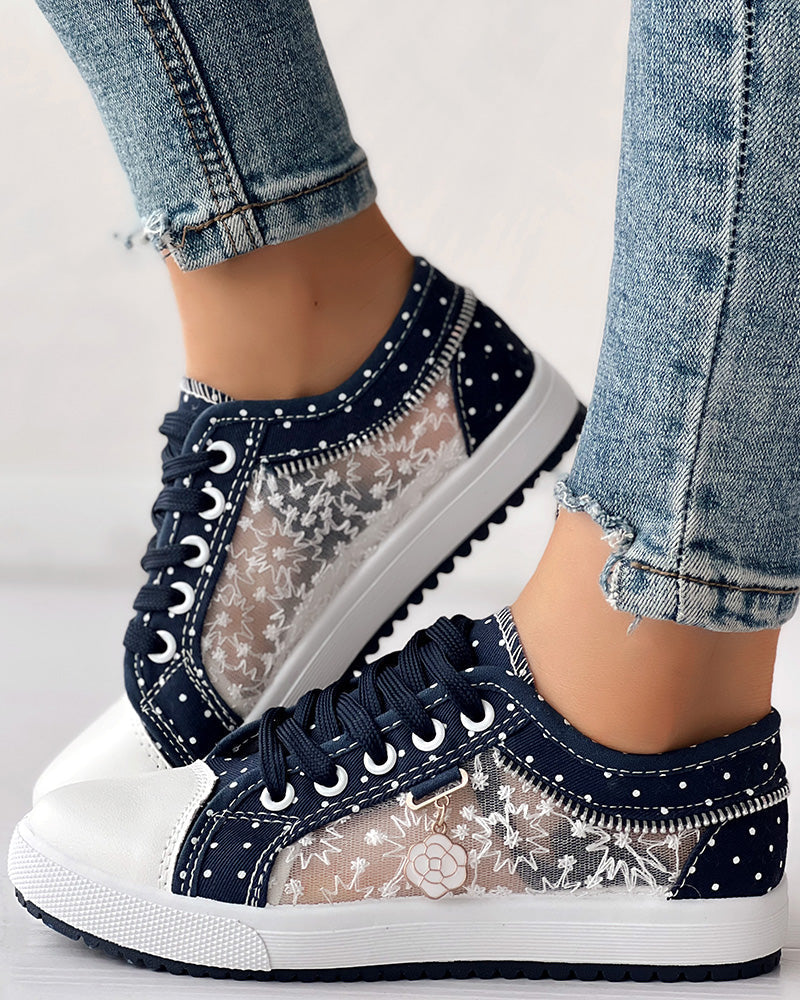 Navy blue sneakers with lace details worn with light blue jeans on a neutral background