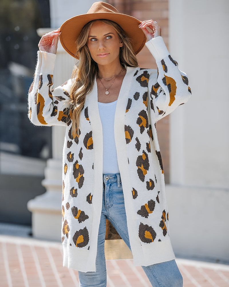 Leopard print longline cardigan with open front, worn over a white top and blue jeans.