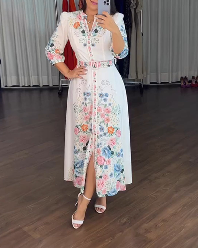 A colorful floral V-neck A-line maxi dress with tie detail, sleeves, and belted waist.