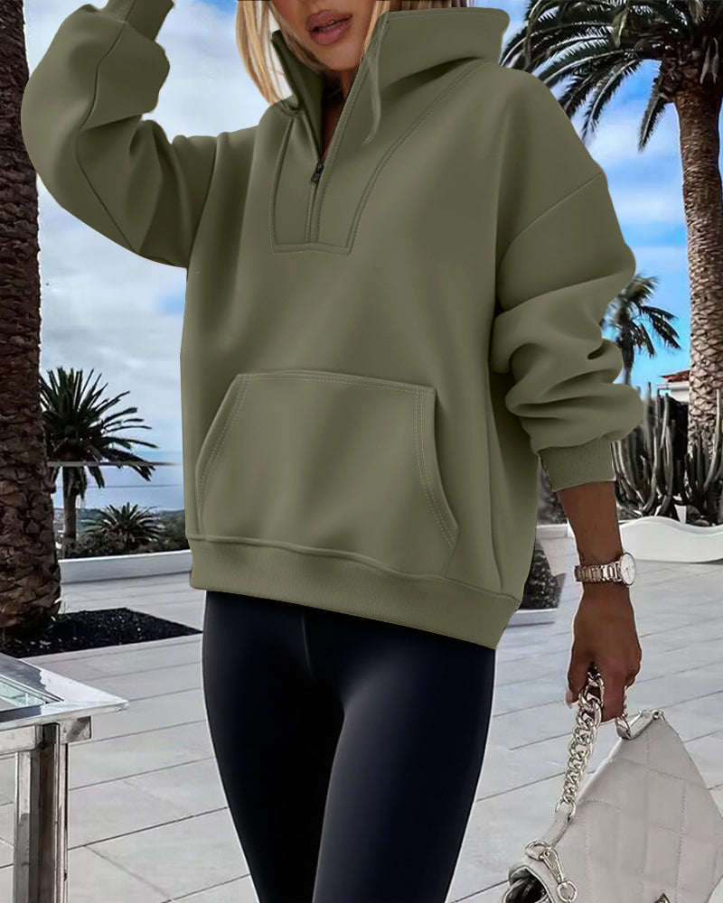Olive green high neck half-zip sweatshirt with kangaroo pocket, drop shoulders, and black leggings.