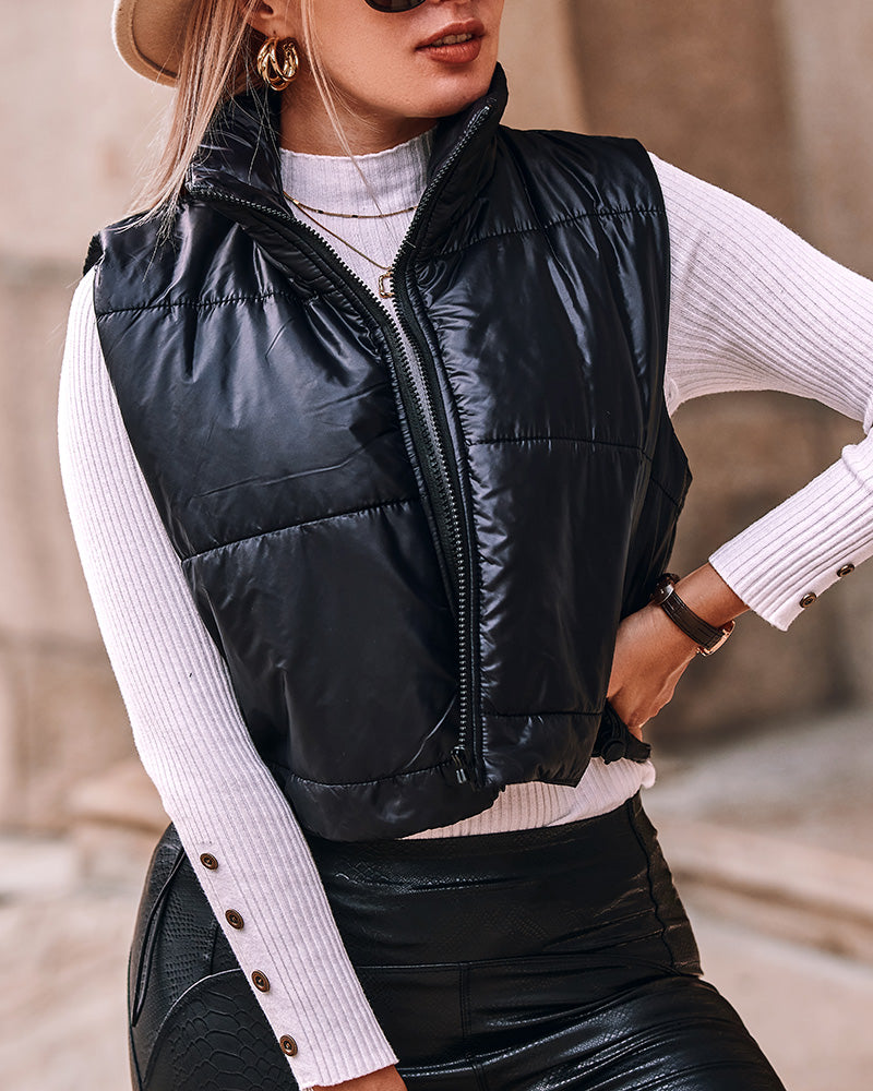 Stand Collar Zip-Up Cropped Puffer Vest with Drawstring Hem over white ribbed top, black pants.