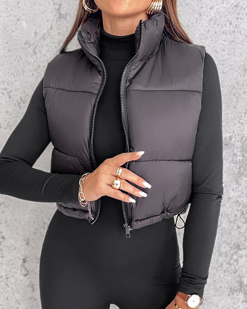 KOAD'CLO stand collar zip-up cropped puffer vest over a fitted black top.