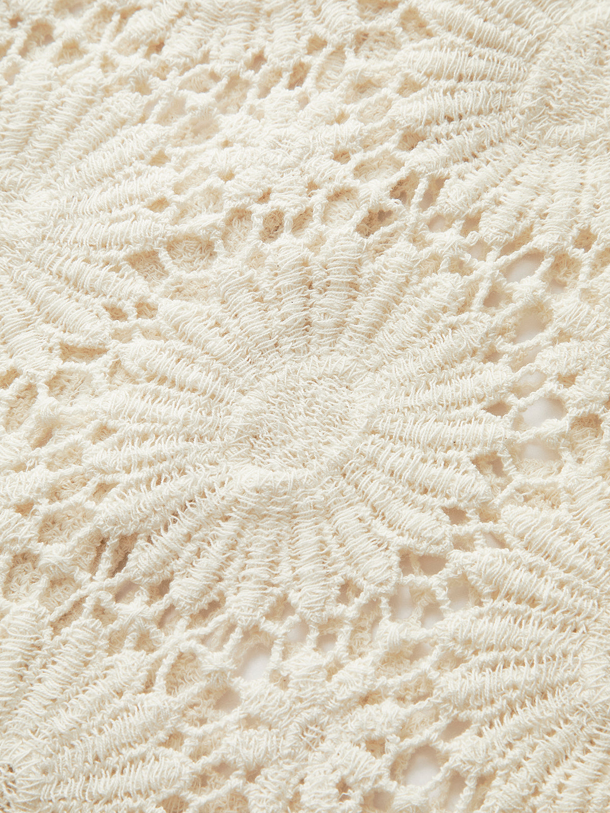 Cream-toned crochet cardigan with button-up front, raised stitching, and intricate floral lace pattern.