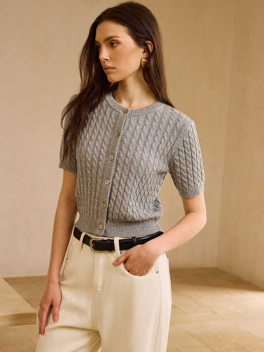 Short-sleeve cable knit cardigan sweater paired with cream high-waisted pants and black belt.